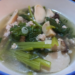 Bowl of Cambodian clear soup with sliced king oyster mushrooms, choi sum greens, ground pork, and scallions in light broth