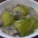 Stuffed Cambodian wax gourd pieces filled with minced pork and Longkou vermicelli, served in a light broth in a white bowl with scattered green onion.