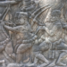 Bas-relief at Bayon temple showing Khmer archers and crossbowmen marching in formation, carved in sandstone with detailed clothing and weaponry.