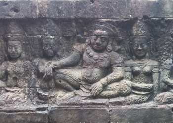 Bas-relief of Yama seated with attendants on the Terrace of the Leper King at Angkor Thom, Cambodia, carved in weathered sandstone with intricate Khmer details.