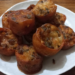 Plate of small round Cambodian pork trotter cakes (nom cheung chrouk), deep-fried to a golden brown, showing crisp edges and speckled peanuts.