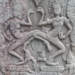 Dancing apsaras bas-relief at Bayon temple in Angkor Thom, showing two elaborately adorned celestial dancers carved in weathered sandstone.
