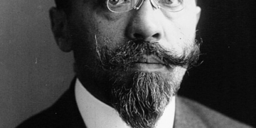 Black‑and‑white studio portrait of Albert Sarraut in 1914, shown from the chest up in a dark suit, white shirt and patterned tie, facing the camera against a plain, dark background.