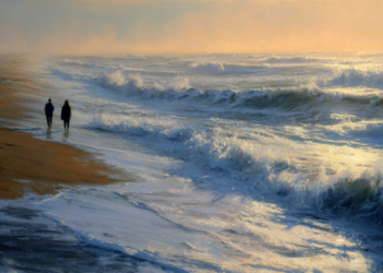 Two people walking along a wet sandy beach at dusk beside foaming waves, with golden light from the setting sun reflecting on the ocean and low clouds in the distance.