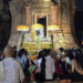 De nuit, au temple de Lolei dans la province de Siem Reap, un groupe de fidèles assis sur des nattes fait face à un ancien sanctuaire en briques illuminé, décoré de parasols jaunes, de fleurs et d’offrandes, en attendant le moment précis fixé par la position de la lune pour lancer une cérémonie de la Fête de l’Eau.