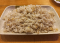 Rectangular plate of Cambodian rice sautéed with finely chopped garlic, served on a wooden table in a small Kampong Thom street restaurant.