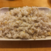 Rectangular plate of Cambodian rice sautรฉed with finely chopped garlic, served on a wooden table in a small Kampong Thom street restaurant.