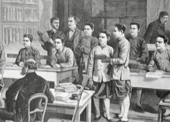 Black and white illustration of a classroom at the École cambodgienne in Paris, showing Cambodian male students in traditional garments standing and sitting at wooden desks while two European teachers supervise the lesson from the front and back of the room.