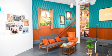 Retro Khmer living room set with orange armchairs, sofa and vintage TV forming a karaoke corner at the “Angkêt de mots: When Khmer Meets French” exhibition in Phnom Penh.