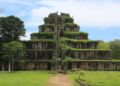 Stone pyramid temple of Prasat Thom at Koh Ker, Cambodia, seen from the front with steep central stairway and green vegetation covering its tiers.