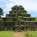Stone pyramid temple of Prasat Thom at Koh Ker, Cambodia, seen from the front with steep central stairway and green vegetation covering its tiers.