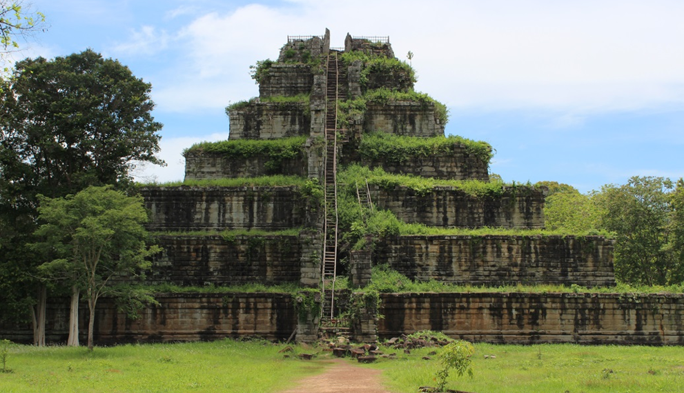Stone pyramid temple of Prasat Thom at Koh Ker, Cambodia, seen from the front with steep central stairway and green vegetation covering its tiers.