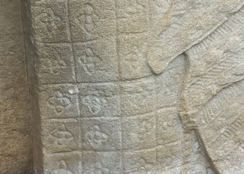 Close view of an Preah Khan Apsara sandstone skirt showing grid based Kbach floral motifs that resemble elements of the modern Louis Vuitton monogram.