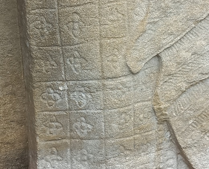 Close view of an Preah Khan Apsara sandstone skirt showing grid based Kbach floral motifs that resemble elements of the modern Louis Vuitton monogram.
