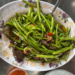 Stir-fried morning glory with chicken innards, chilies and garlic on a floral plate at a local eatery at Phnom Chisor temple in Takeo, Cambodia.