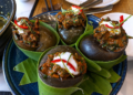 Snail amok served in large snail shells at Kraya Angkor Restaurant in Phnom Penh, featuring rich Cambodian coconut curry, fresh herbs, chili, and elegant presentation.