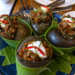 Snail amok served in large snail shells at Kraya Angkor Restaurant in Phnom Penh, featuring rich Cambodian coconut curry, fresh herbs, chili, and elegant presentation.