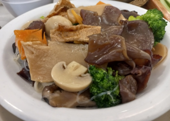 Plate of Buddha’s Delight vegetarian dish with tofu, mushrooms, broccoli, glass noodles, and mixed vegetables at Fisherman Quay restaurant in Phnom Penh, Cambodia.