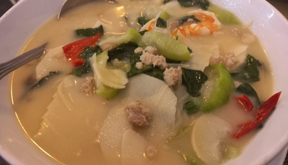 Traditional Cambodian bamboo shoot soup with bamboo shoots, shrimp, minced pork, leafy greens, and vegetables served in a light broth.