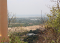 Panoramic view of the Cambodian countryside from the top of Phnom Basith in Kandal Province, showing forests, fields, and distant landscapes under a clear sky.