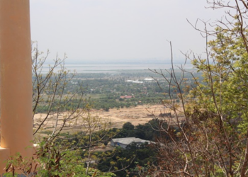 Panoramic view of the Cambodian countryside from the top of Phnom Basith in Kandal Province, showing forests, fields, and distant landscapes under a clear sky.