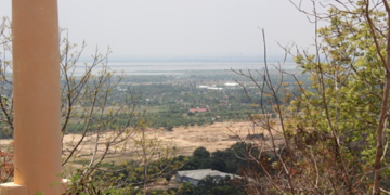 Panoramic view of the Cambodian countryside from the top of Phnom Basith in Kandal Province, showing forests, fields, and distant landscapes under a clear sky.