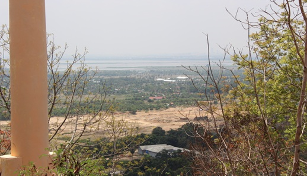 Panoramic view of the Cambodian countryside from the top of Phnom Basith in Kandal Province, showing forests, fields, and distant landscapes under a clear sky.