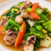 Sautéed vegetables with pork in a light savory sauce, a traditional Cambodian home-style dish featuring fresh greens, mushrooms, carrots, and broccoli.