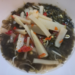 A bowl of Cambodian pickled bamboo shoots with African cabbage, chilies, bean sprouts, and herbs in a light brine.