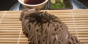 Soba noodles served on a bamboo mat with dipping sauce, wasabi, and nori at Iza restaurant, Rosewood Phnom Penh.