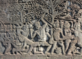 Bayon bas-relief showing Khmer warriors fighting Champa soldiers wearing distinctive helmets.