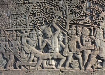 Bayon bas-relief showing Khmer warriors fighting Champa soldiers wearing distinctive helmets.