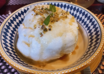 Floating island dessert with meringue, nuts, mint, and crème anglaise at La Ferme de Bassac Restaurant in Siem Reap, Cambodia.