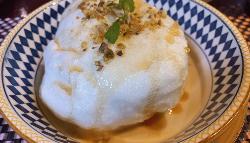 Floating island dessert with meringue, nuts, mint, and crème anglaise at La Ferme de Bassac Restaurant in Siem Reap, Cambodia.