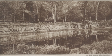 Historic ca. 1938 photograph of the Terrace of the Elephants in Angkor Thom, Cambodia, showing Khmer carvings, trees, and reflected water.