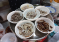 Bowls of meat, pork offal, meatballs, and other ingredients for បបរសាមចូក at Central Market in Phnom Penh, Cambodia
