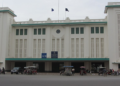 Historic Phnom Penh Railway Station with its distinctive Art Deco architecture, central clock, green accents, and busy street scene.