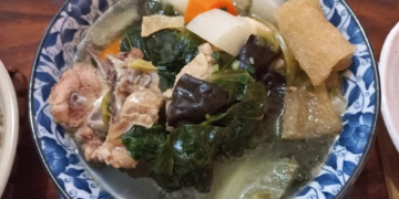A bowl of Cambodian chap chay with vegetables, pork, tofu skin, and wood ear mushrooms.