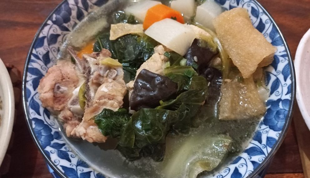 A bowl of Cambodian chap chay with vegetables, pork, tofu skin, and wood ear mushrooms.