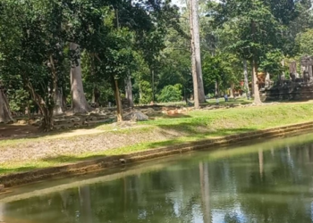 Eastern façade of Bayon Temple reflected in the moat at Angkor Thom, Cambodia