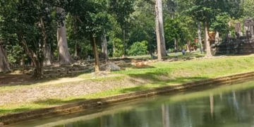 Eastern façade of Bayon Temple reflected in the moat at Angkor Thom, Cambodia