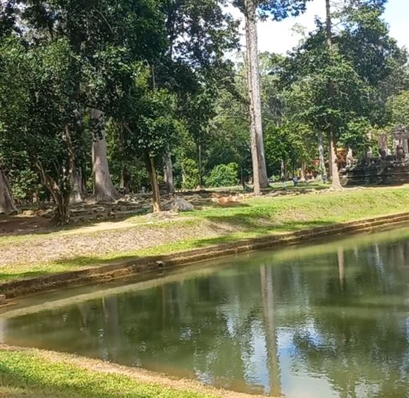 Eastern façade of Bayon Temple reflected in the moat at Angkor Thom, Cambodia