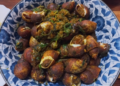Plate of Cambodian sea snails stir-fried with herbs, spices, and seasoning.