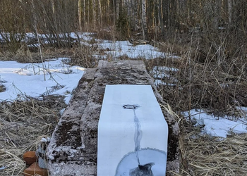 Artwork from Julia Briggs’s Remanence (2022), showing ink melting onto paper on a stone slab in a snowy Finnish forest.