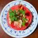 Cambodian hot-season dish of sliced watermelon topped with grilled dried fish, herbs, and spices on a blue-and-white plate.