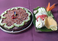 Grilled Cambodian prahok served with fresh raw vegetables, lime, and herbs at Neari Khmer Restaurant in Siem Reap.
