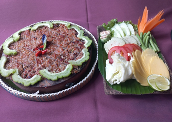 Grilled Cambodian prahok served with fresh raw vegetables, lime, and herbs at Neari Khmer Restaurant in Siem Reap.