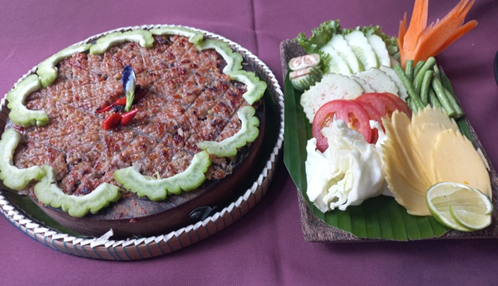 Grilled Cambodian prahok served with fresh raw vegetables, lime, and herbs at Neari Khmer Restaurant in Siem Reap.